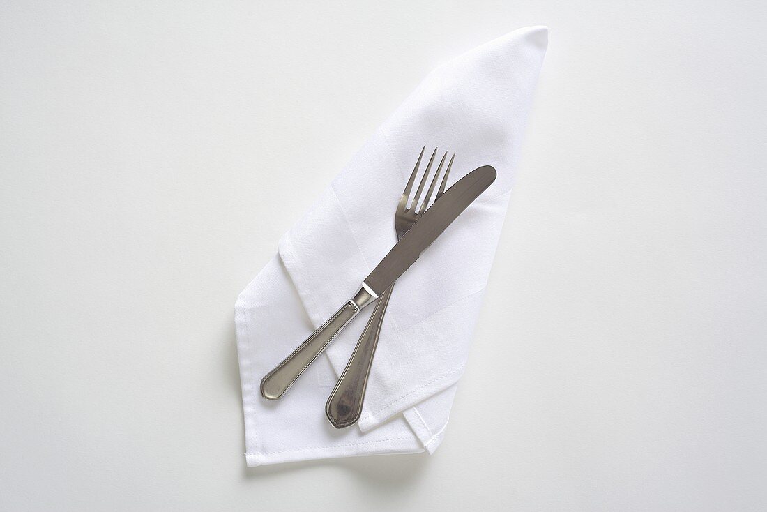 Cutlery on a white napkin, seen from above