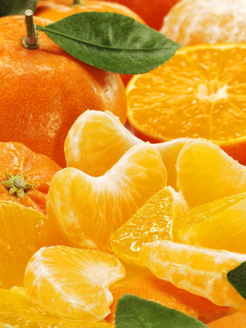 Mandarinen, ganz, halbiert und Spalten (Nahaufnahme)