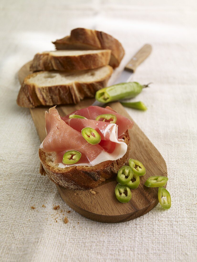 Belegtes Brot mit Serranoschinken und Chiliringen