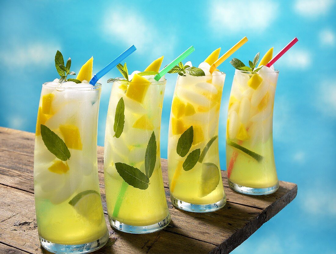 Four Mango Lime Mojitos with Straws on a Table