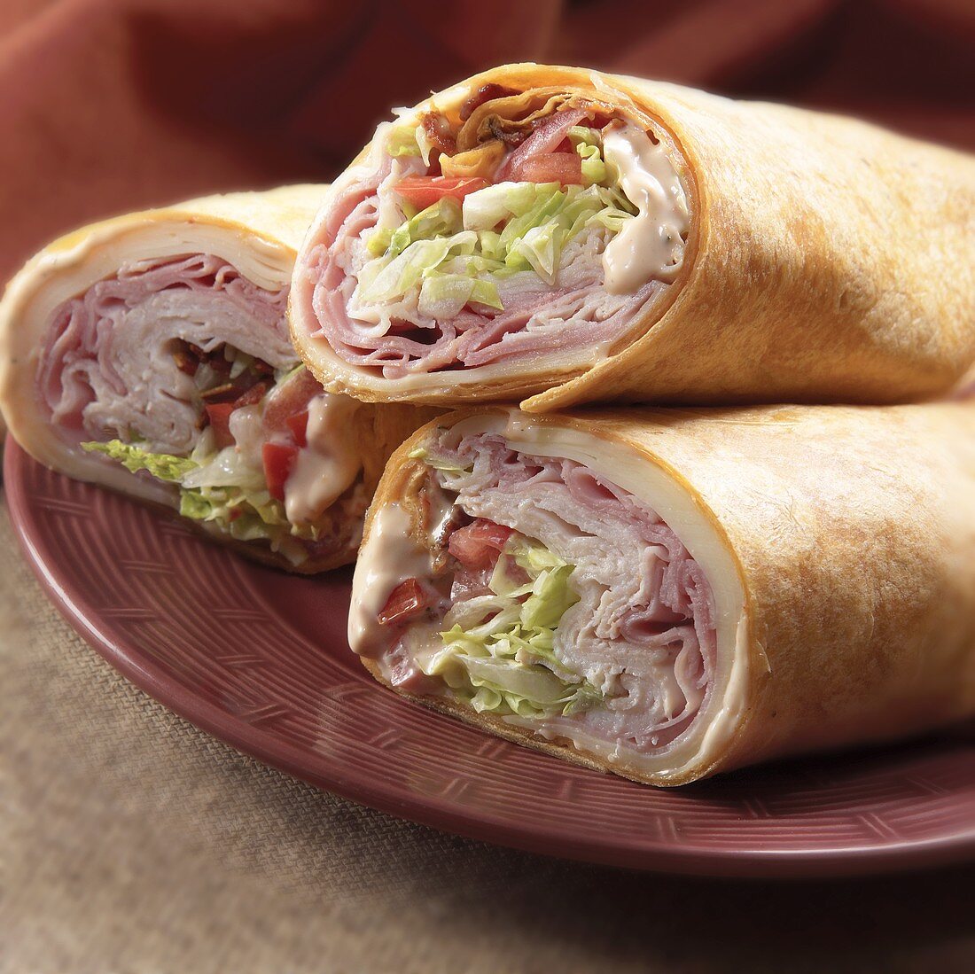 Three Ham and Turkey Wraps on a Plate