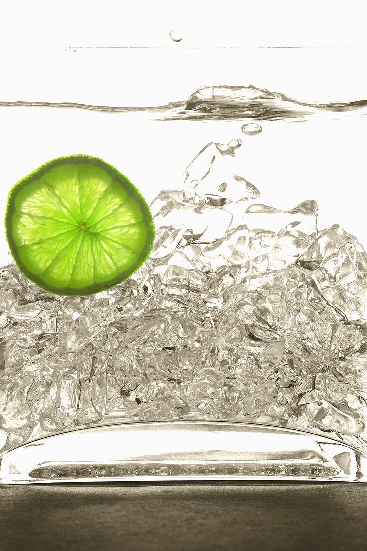 Ice Splashing into Water with Lime Slice