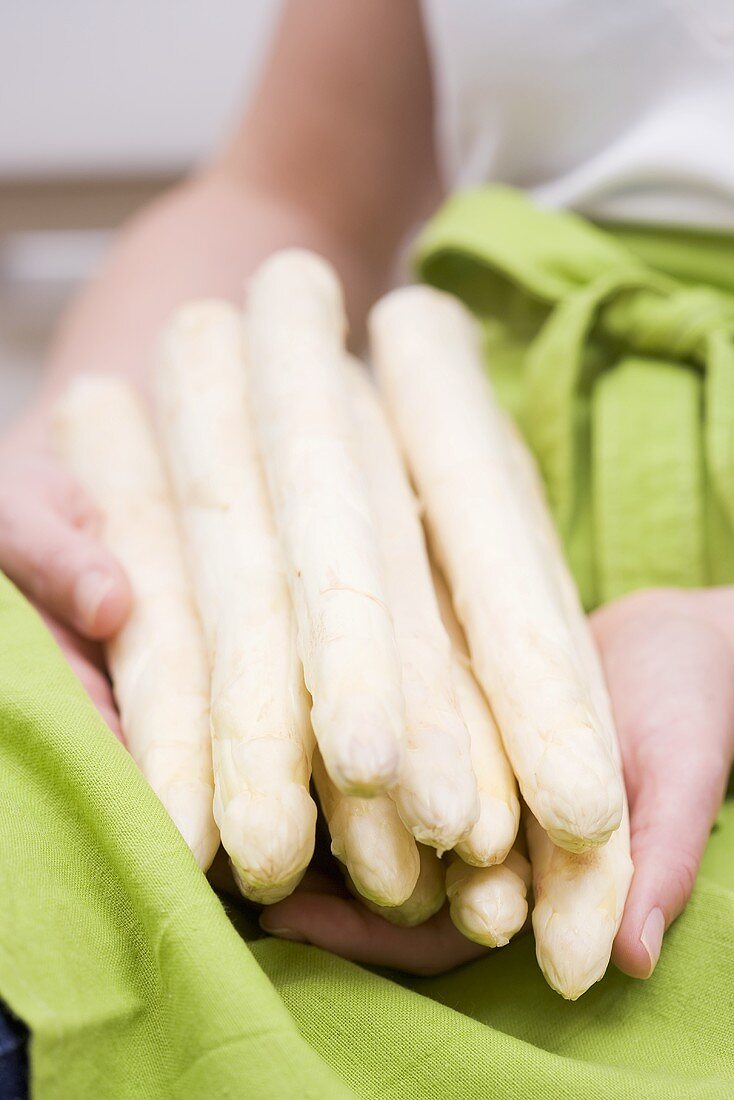 A woman holding white asparagus