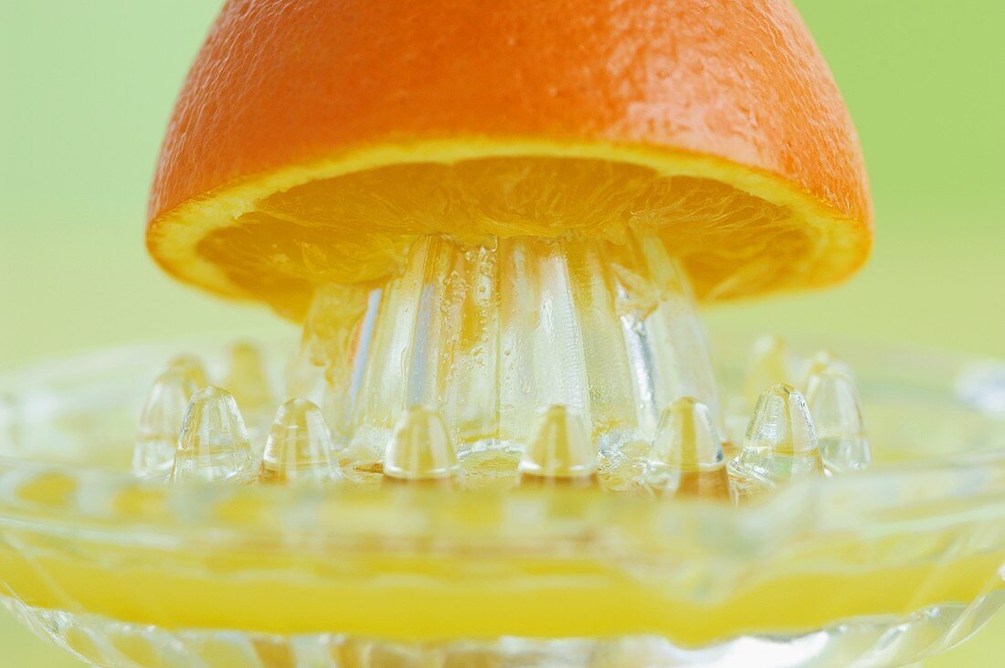 An orange half on a juicer