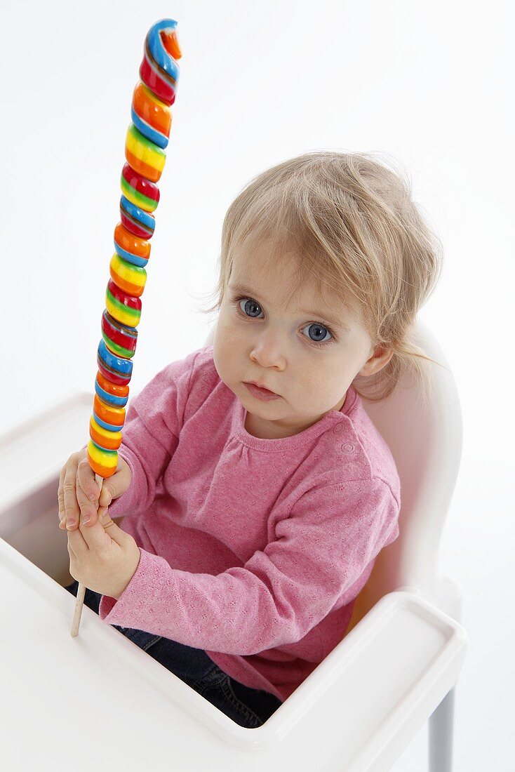 A small child holding a giant lolly
