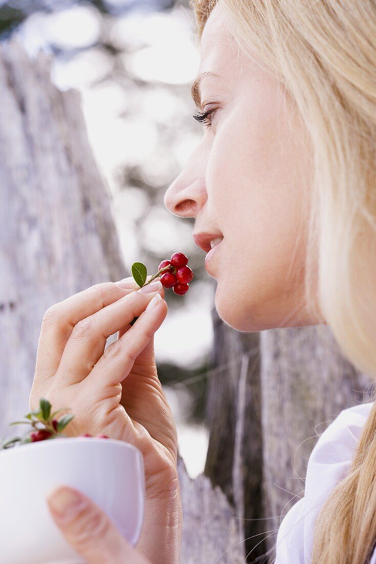 A woman eating fresh lingonberries