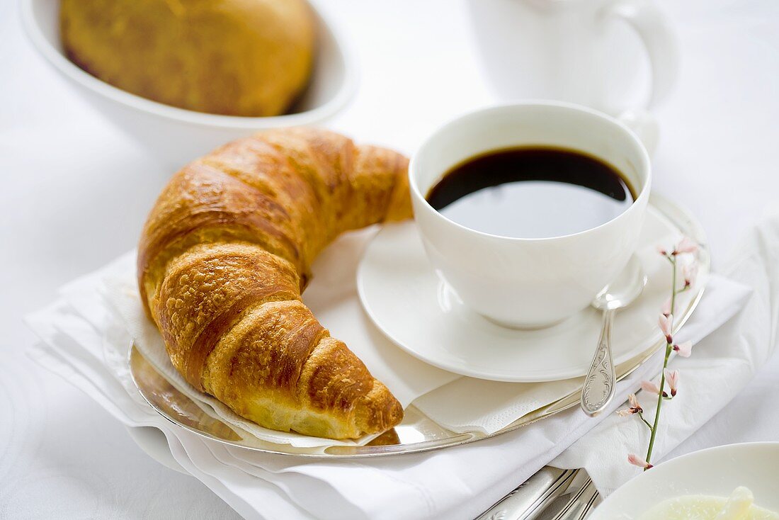 Kaffeetasse und Croissant