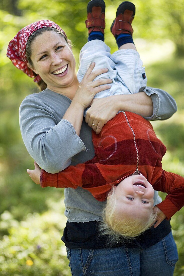 Lachende Mutter hält kleine Tochter