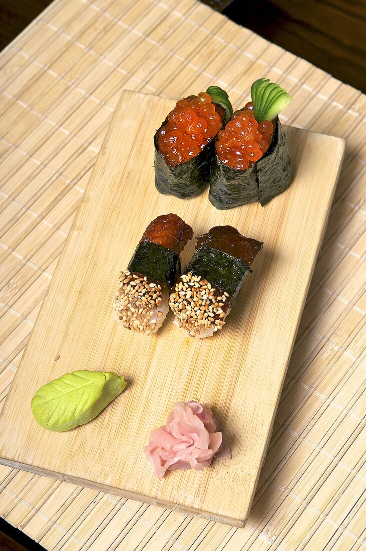 Sushi mit Makrele und Lachskaviar auf Holzbrett
