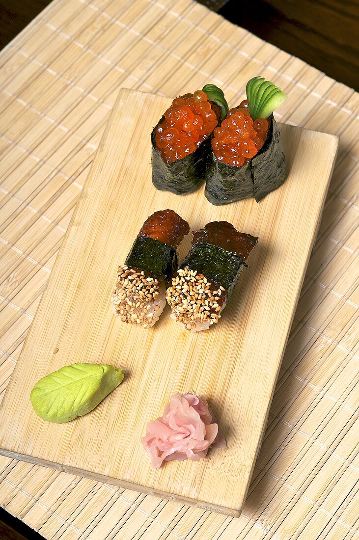 Sushi with mackerel and salmon caviar on a wooden board