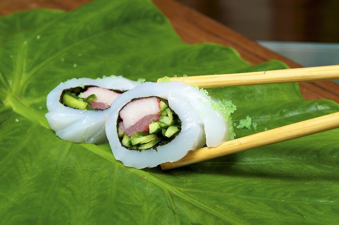 Fish rolls with cucumbers and tuna on a leaf