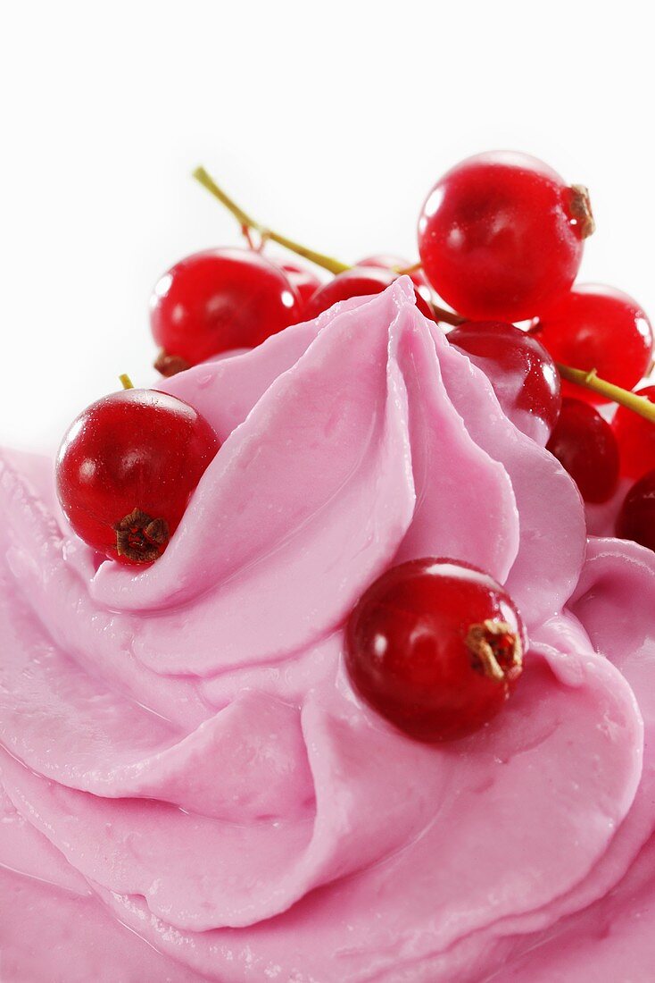 Redcurrant yogurt ice cream garnished with fresh redcurrants (close-up)