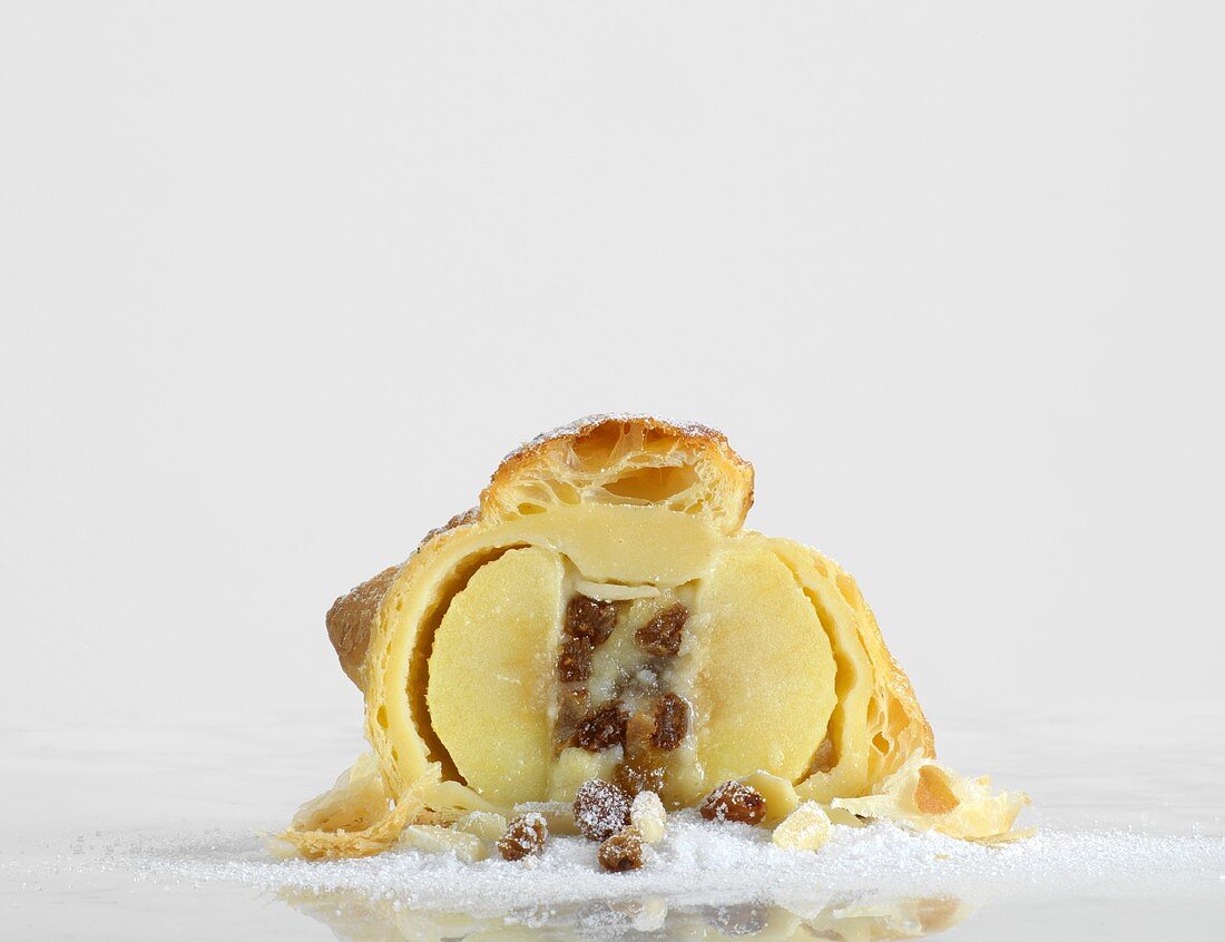 A baked apple in puff pastry, halved