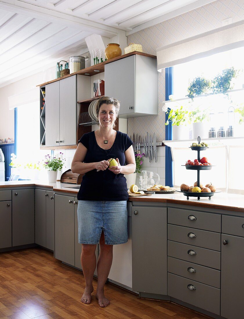 Woman in her kitchen peeling pears
