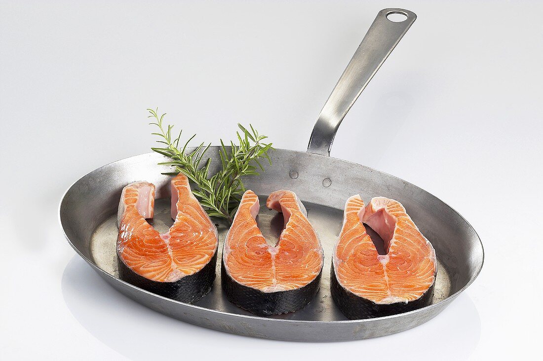 Fresh salmon steaks in a frying pan
