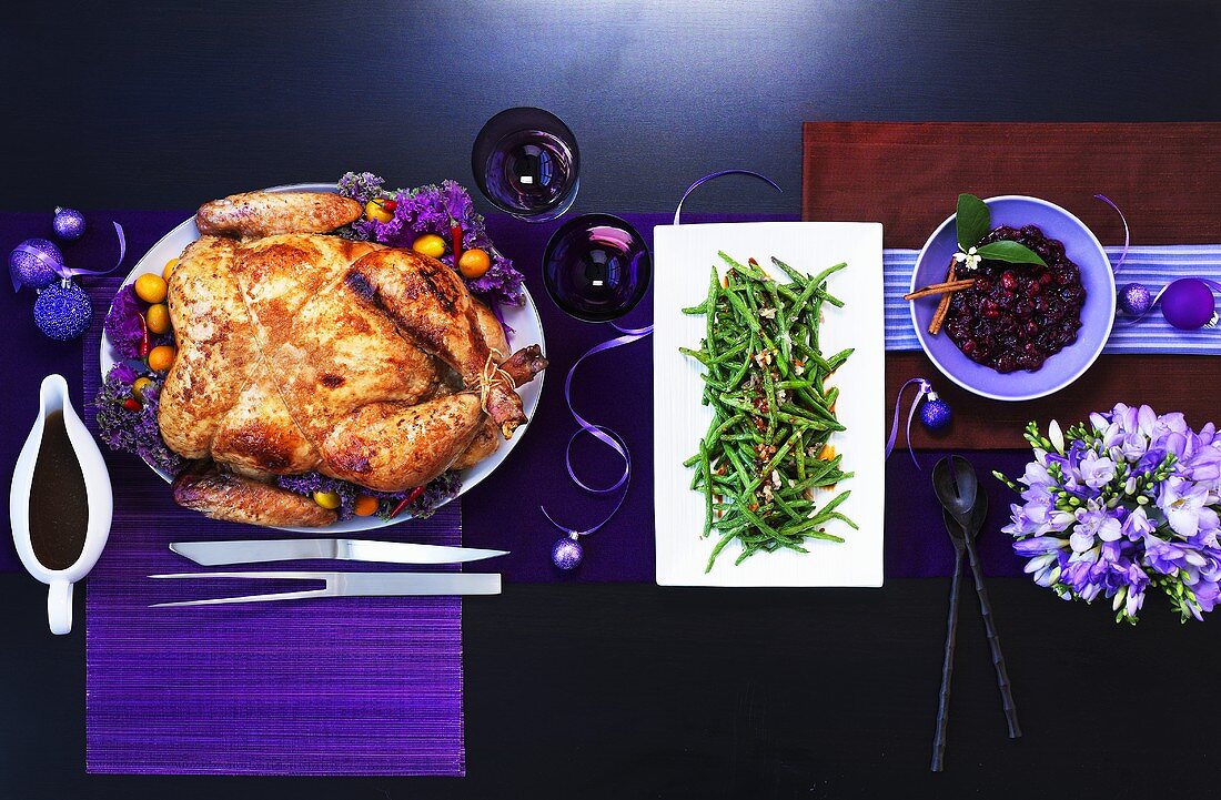 Chinese roasted turkey with green beans on a table with purple decorations