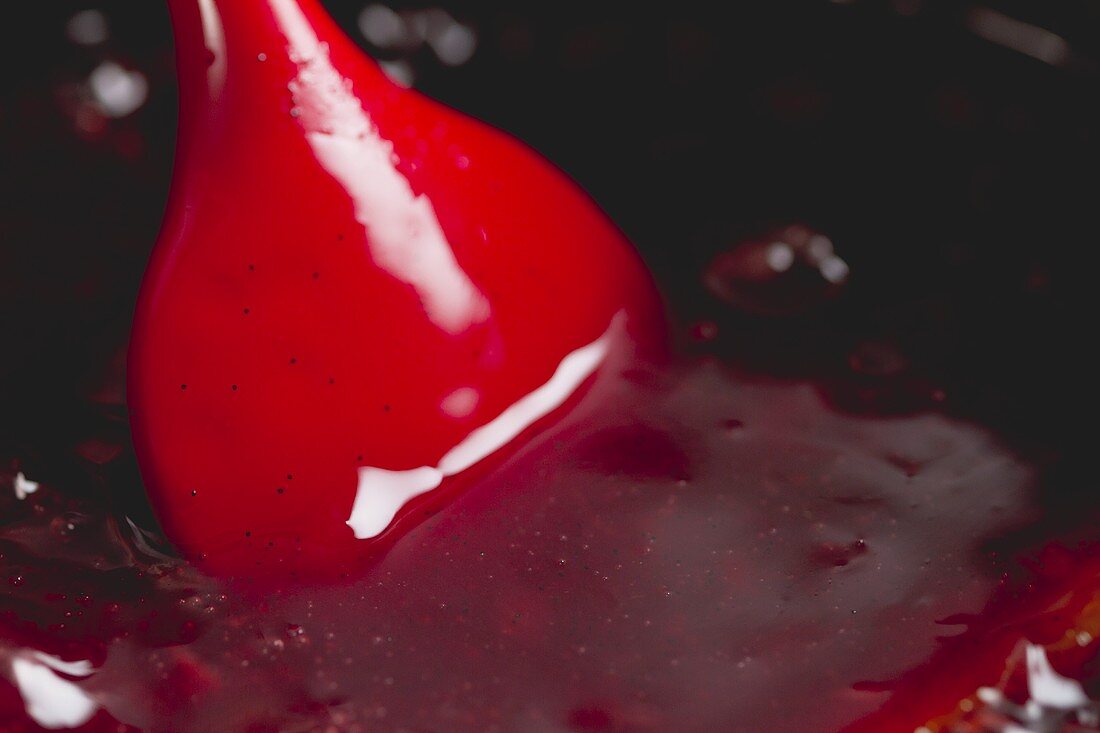 Stirring red fruit jelly