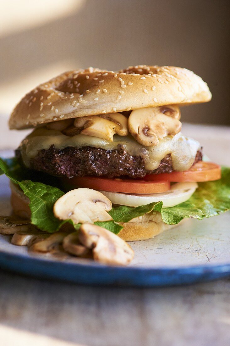 Swiss Cheese Burger with Mushrooms, Tomato, Onion and Lettuce on Sesame Seed Bun