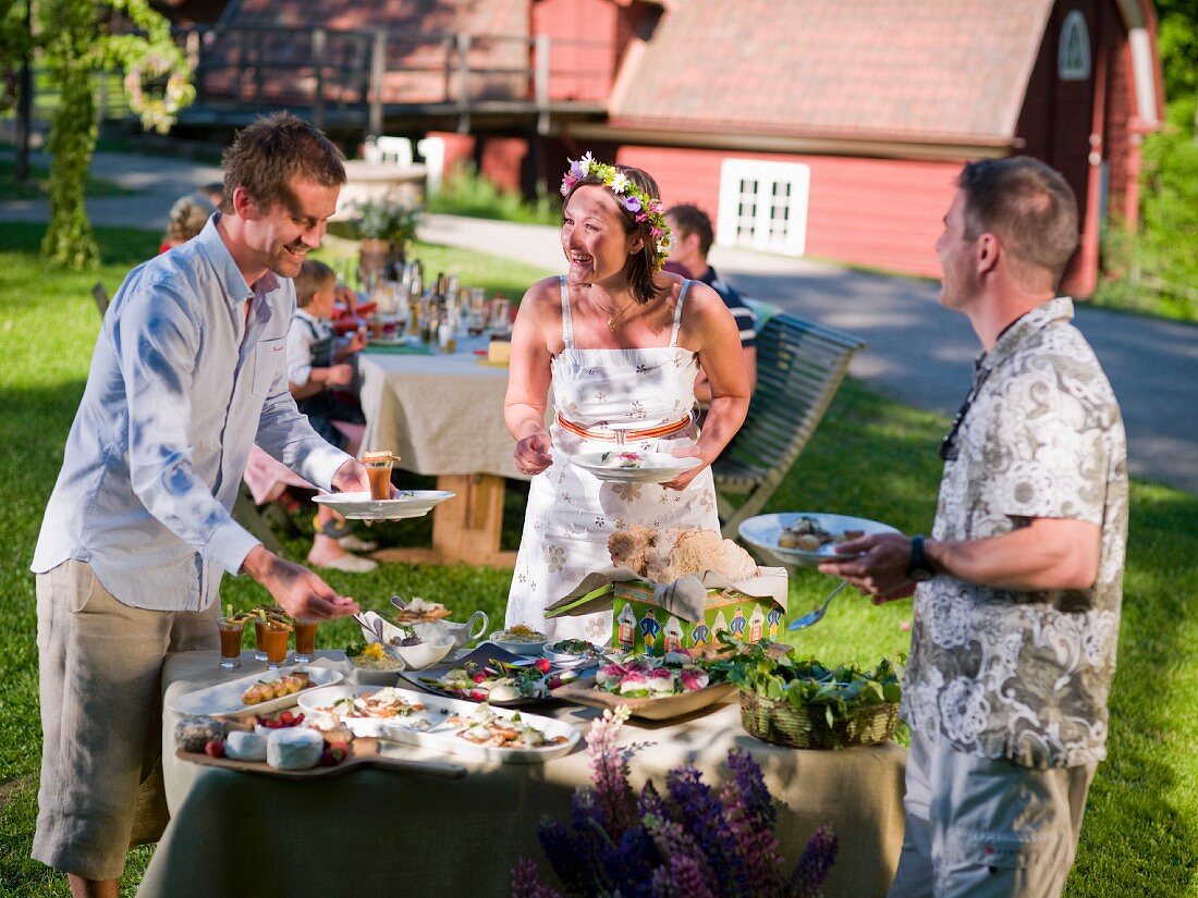 Menschen am Buffet zum Mittsommerfest in Schweden