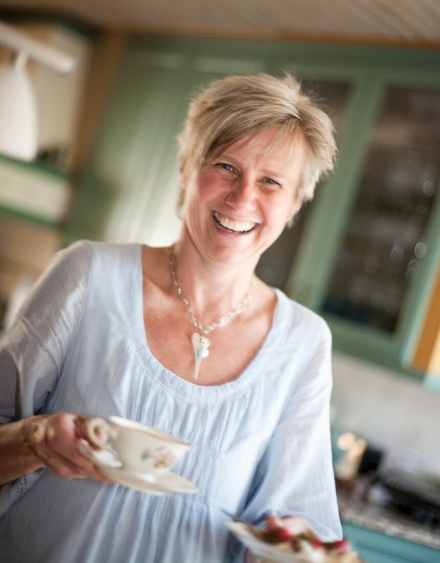 A young woman holding a cup of tea