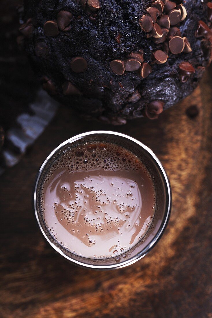 A glass of chocolate milk and a chocolate chip muffin