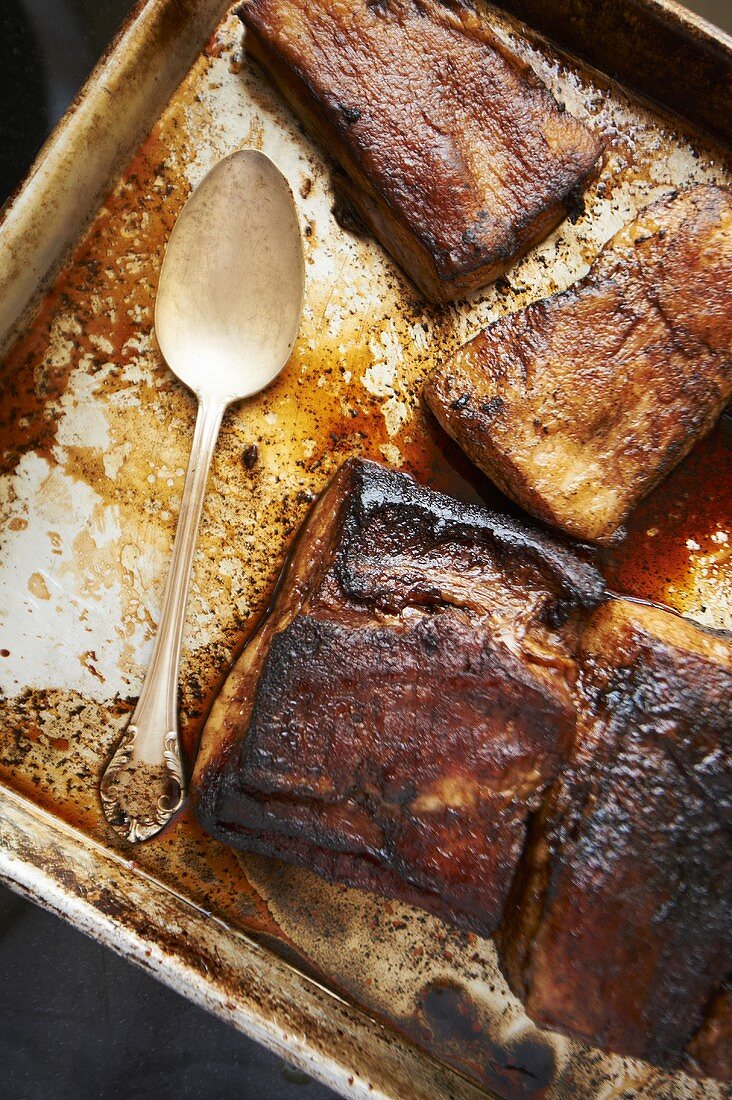 Roasted Pork Belly on a Sheet Pan with Spoon and Pan Juices