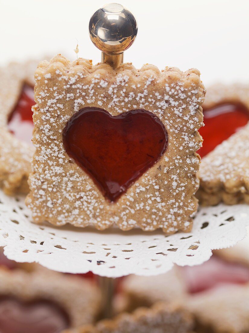 Jam biscuits with icing sugar on a cake stand