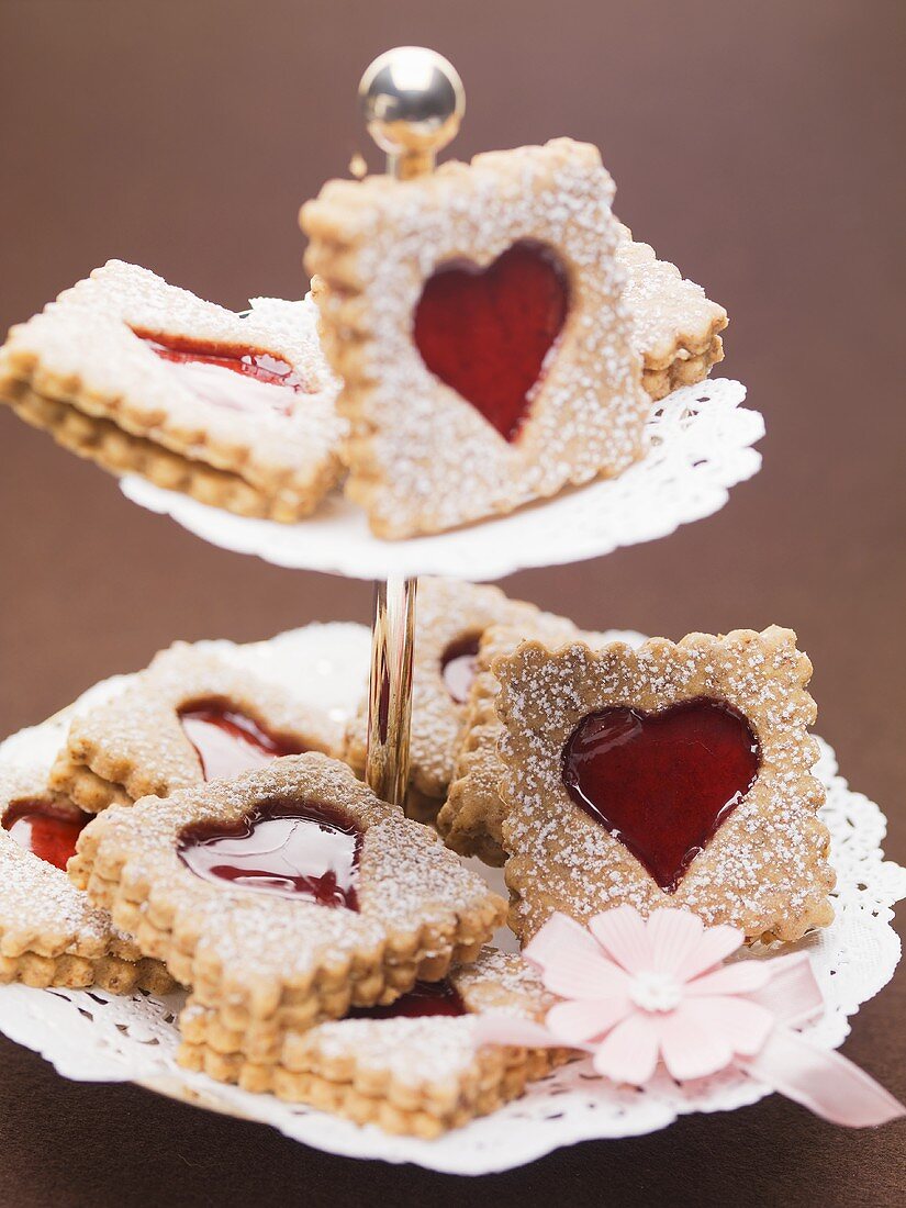 Jam biscuits with icing sugar on a cake stand