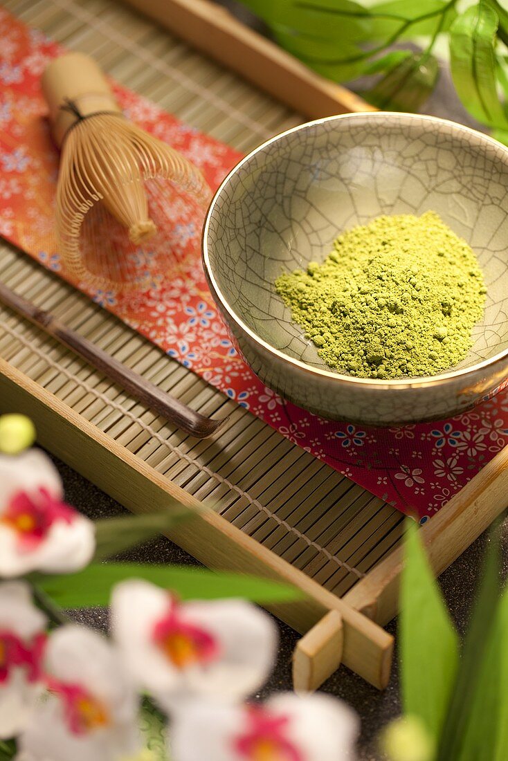 Japanese Matcha Green Tea Powder in a Bowl on Tray; Flowers