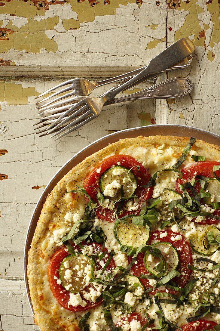 Thin Crust Pizza Topped with Zucchini, Tomatoes, Feta Cheese and Fresh Basil; From Above