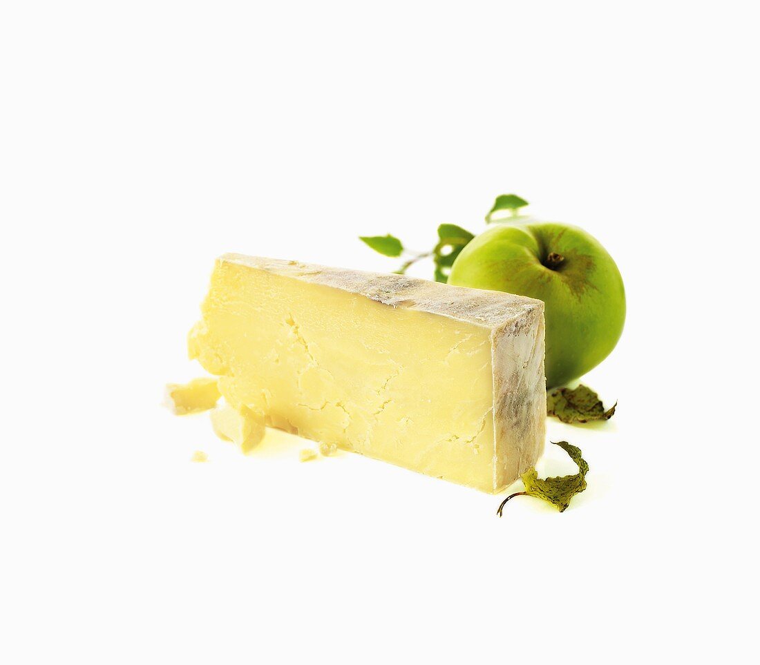 A piece of hard cheese and a green apple