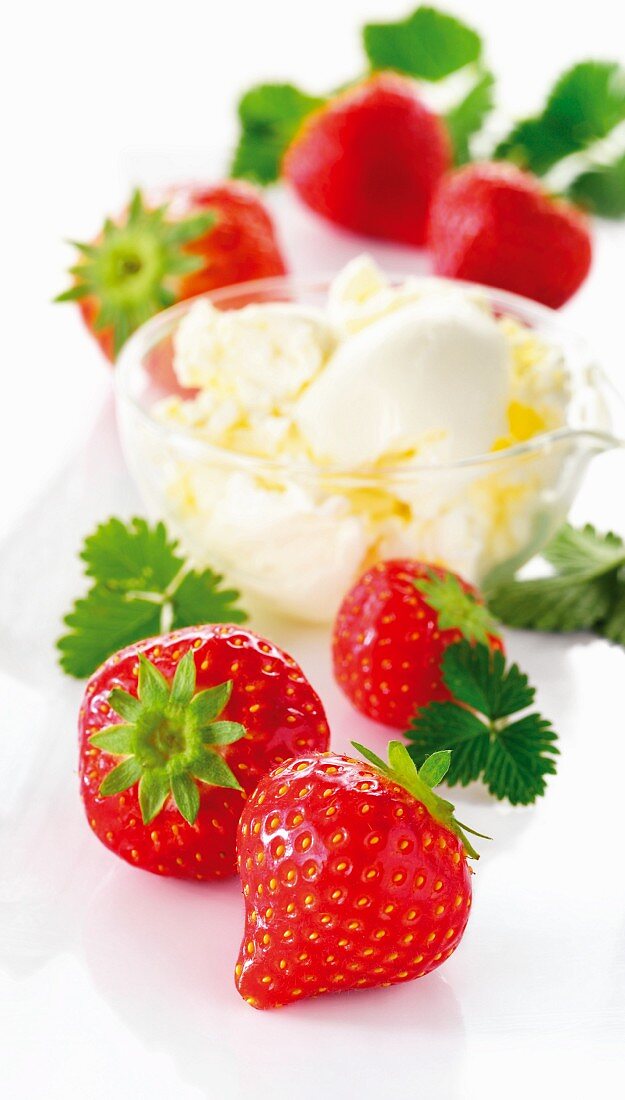 A bowl of vanilla ice cream and fresh strawberries