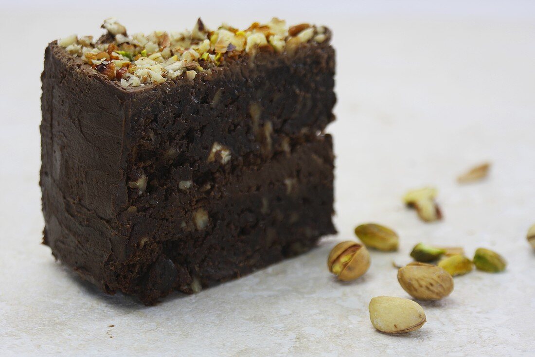 Ein Stück Schokoladen-Brownie-Kuchen mit Nüssen und Pistazien