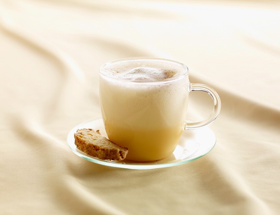 Spiced eggnog in a glass cup with biscotti