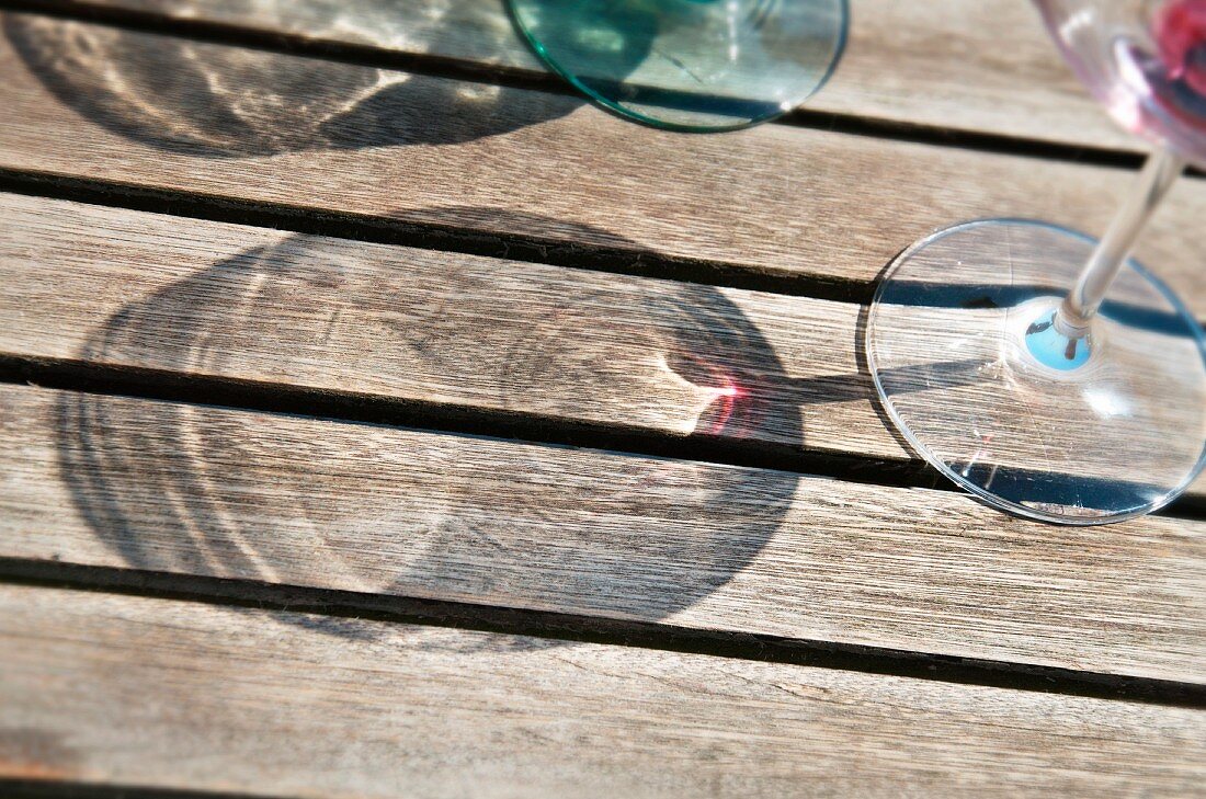 Shadows of wine glasses on a wooden surface