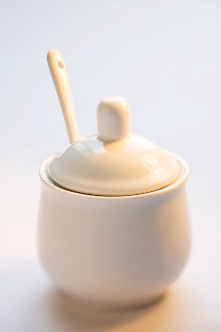 A sugar pot with a spoon