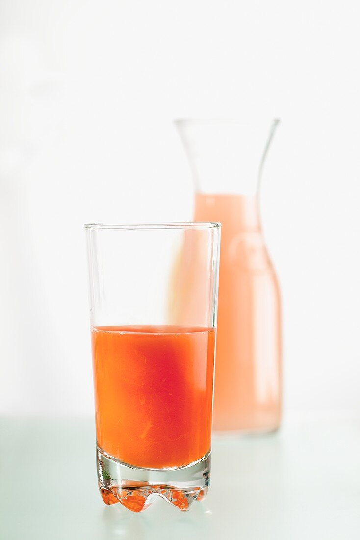 Blood orange juice in a glass and a carafe