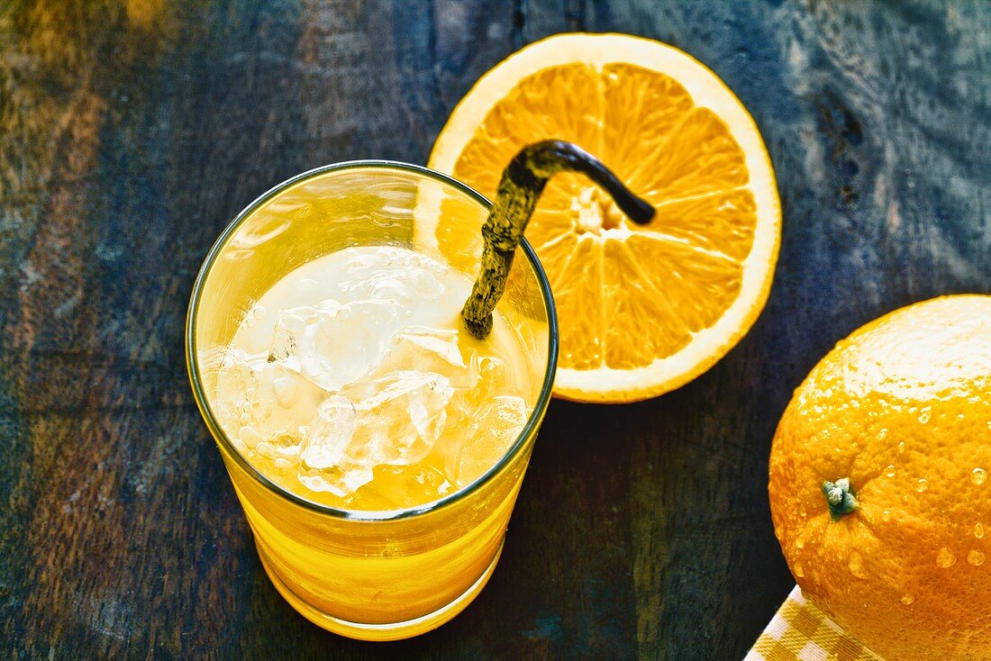 Orange juice with a vanilla pod and ice cubes