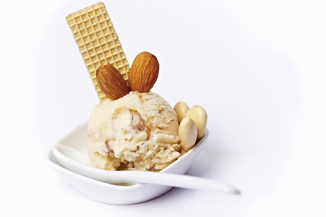 Almond ice cream with almond brittle and a wafer in an ice cream dish