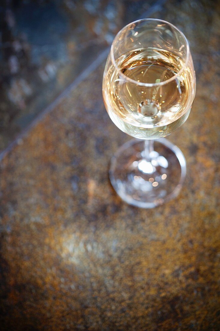 Ein Glas Weißwein auf Steinoberfläche