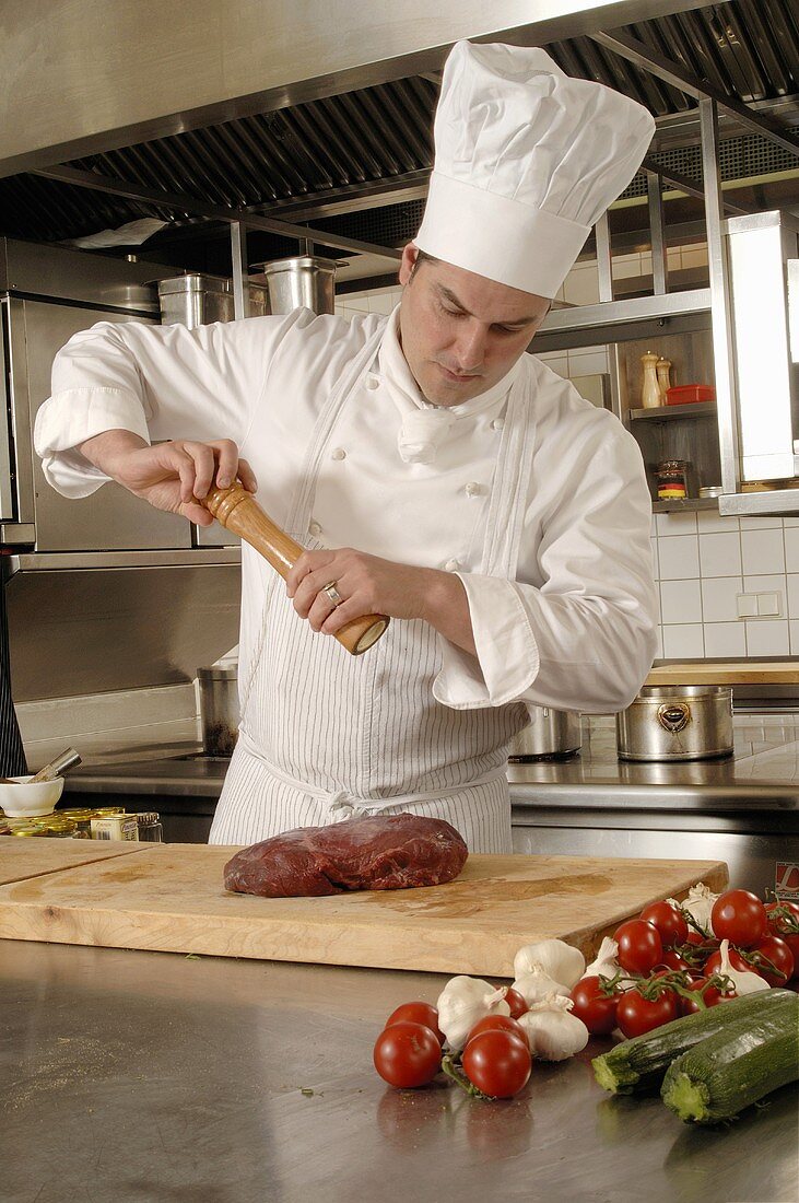 Chef peppering a joint of meat