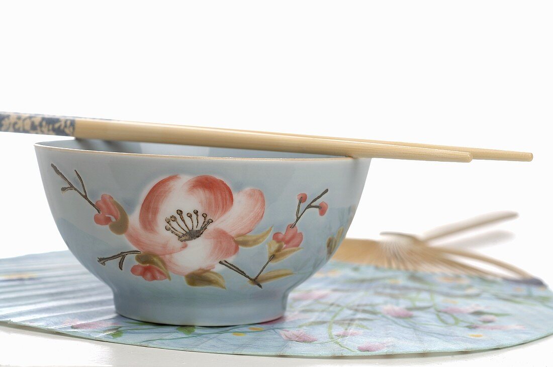 Asian bowl with chopsticks on fan