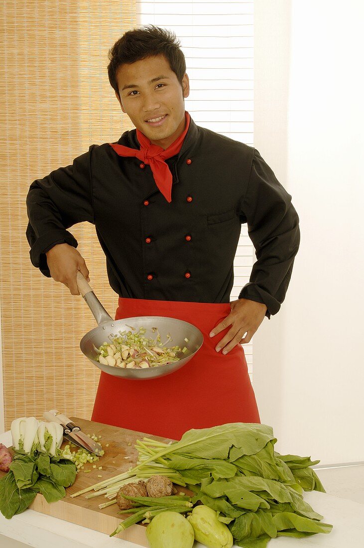 Asiatischer Koch mit Wokpfanne