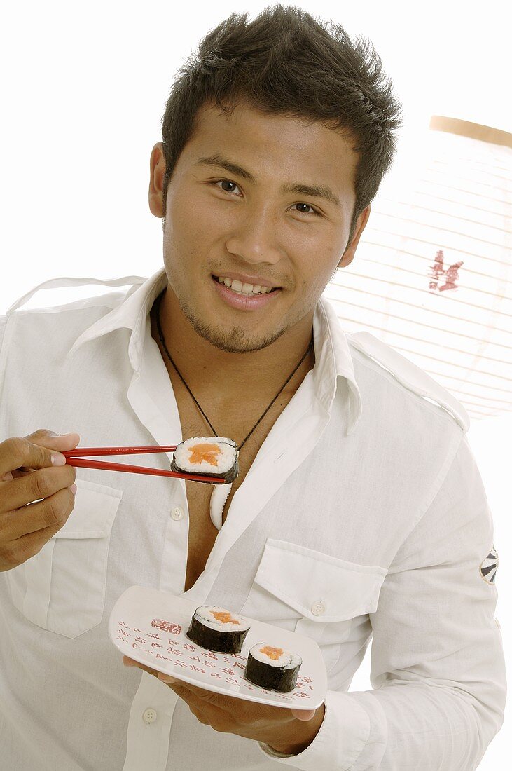 Man eating sushi with chopsticks