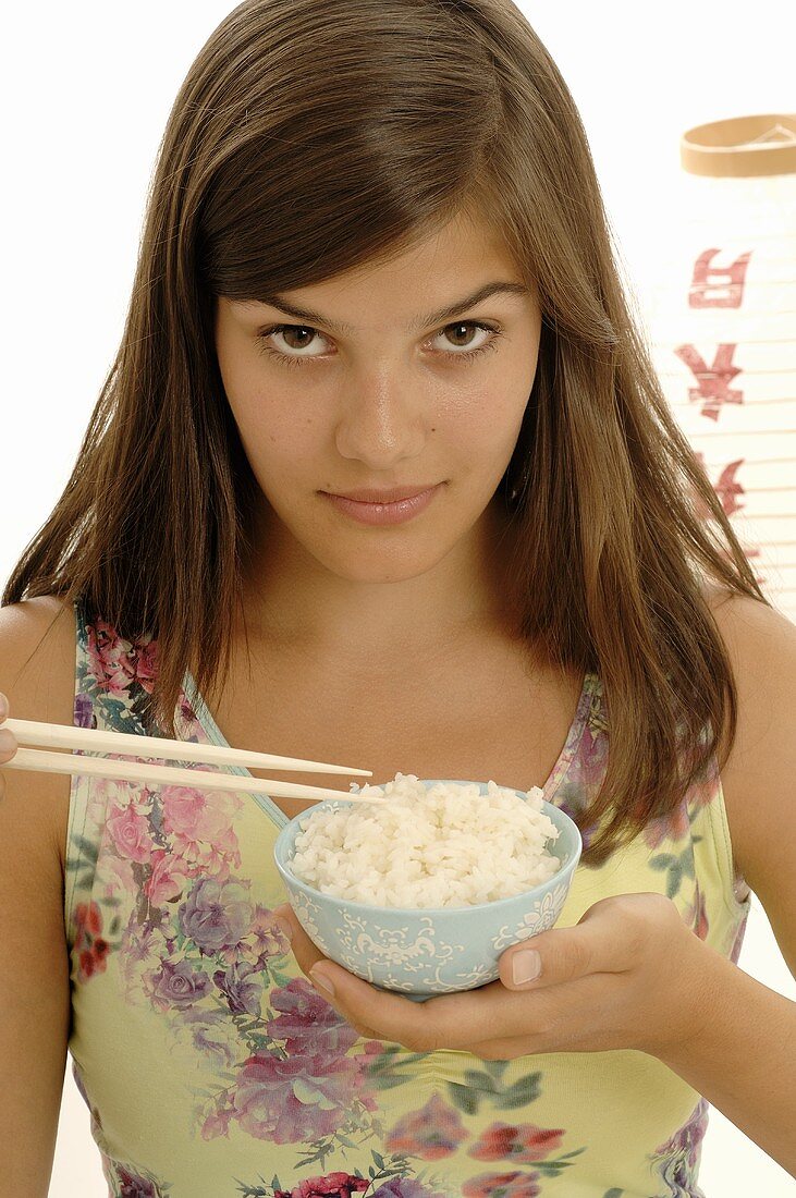 Woman eating rice with chopsticks