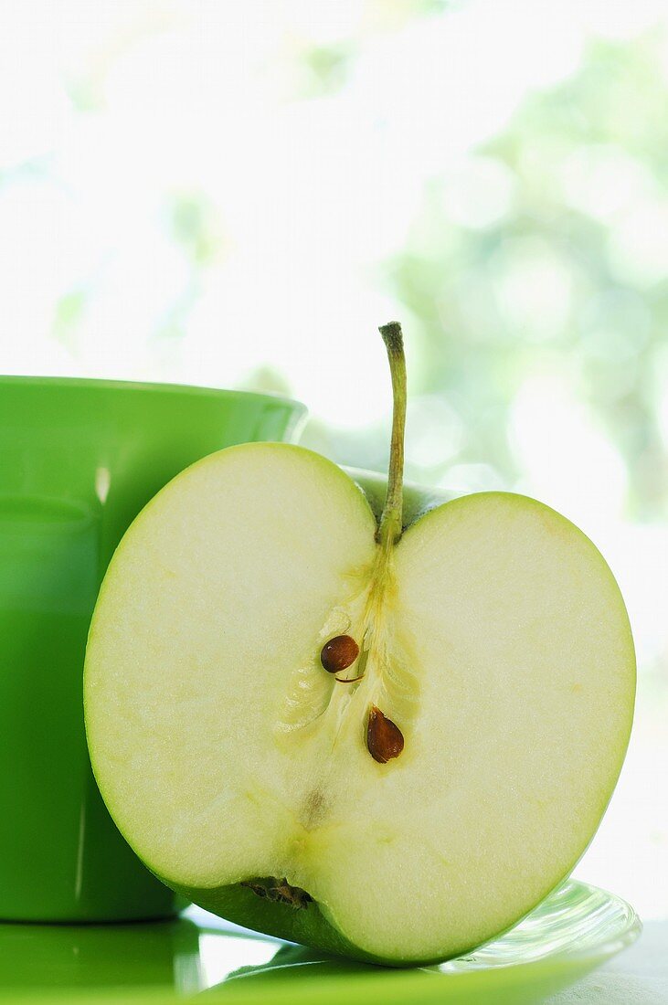 Half an apple and green beaker
