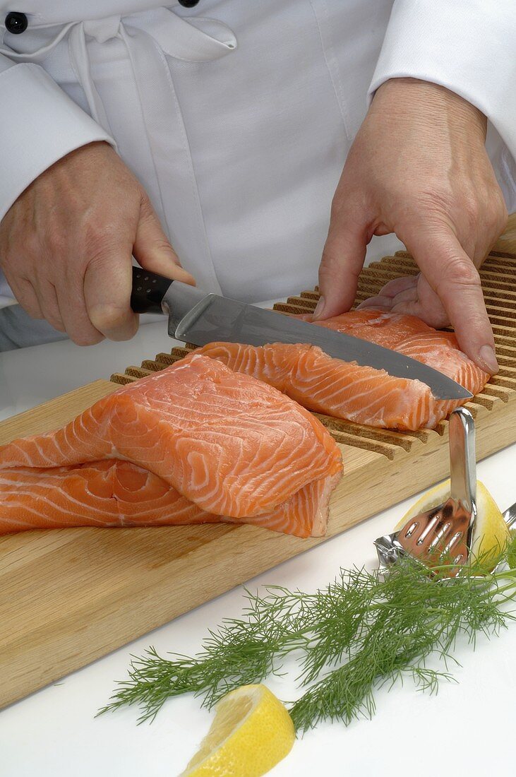 Chef cutting salmon