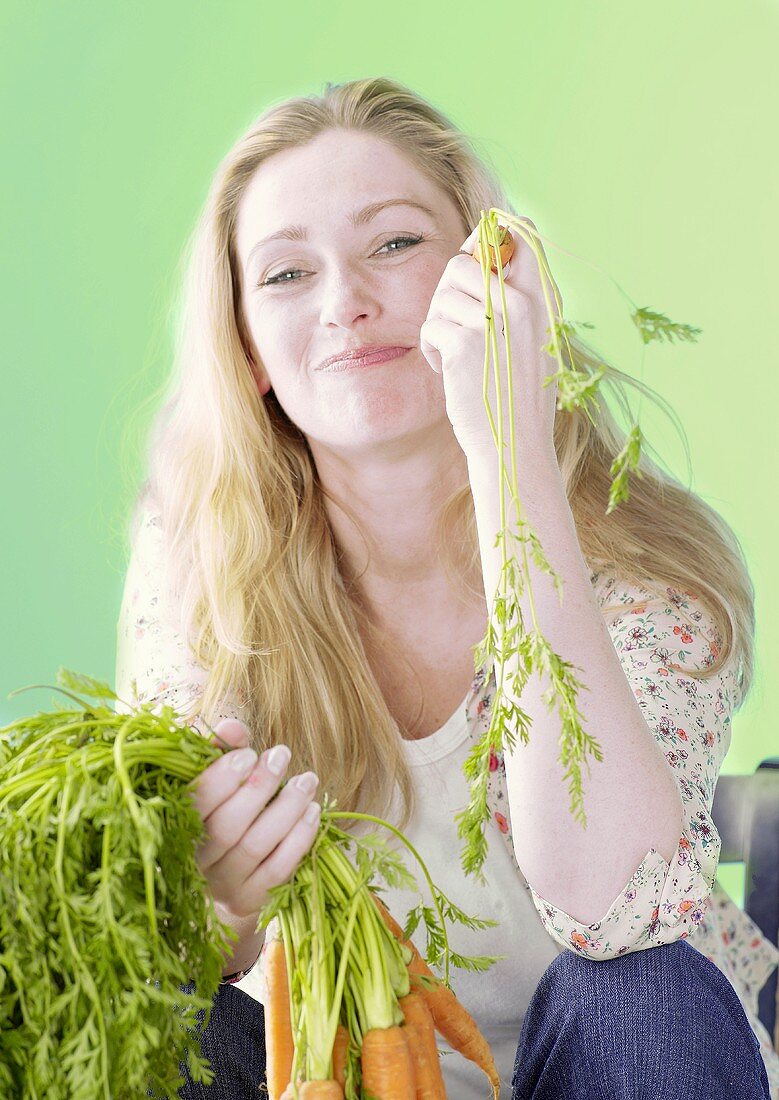 Woman holding fresh carrots