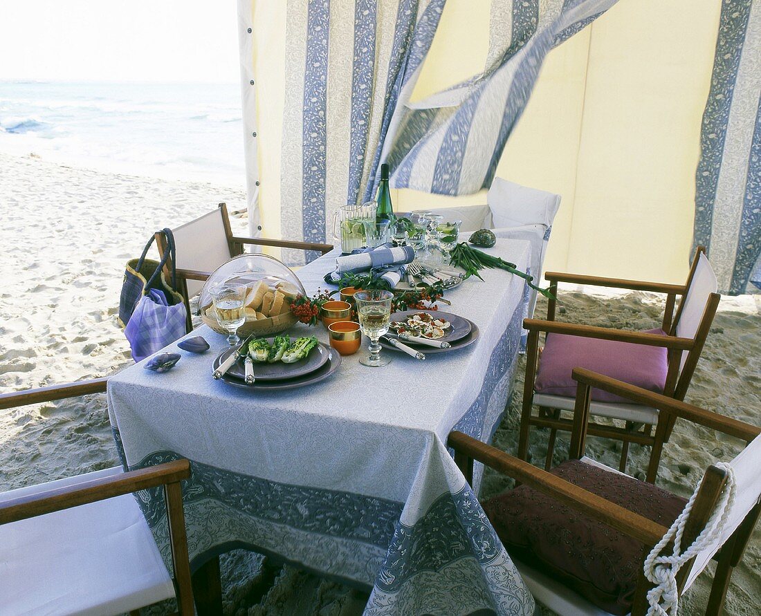Gedeckter Tisch in einem Pavillon am Strand
