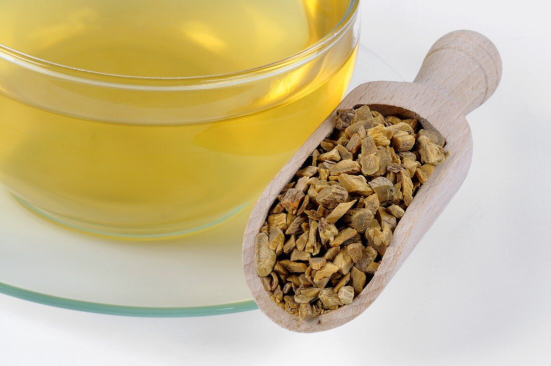 Baikal skullcap root in a wooden scoop with cup of tea